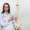 Doctor with spine model, indicative of a spinal stenosis