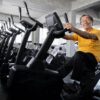 Senior man cycling in gym, showcasing active living to slow Progression of Osteoarthritis
